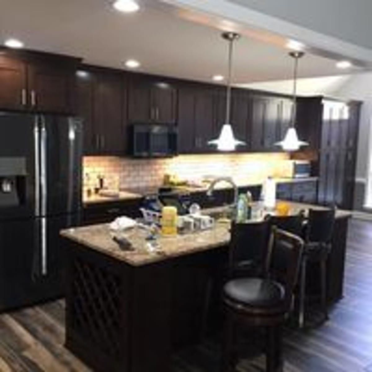 Renovated kitchen with white cabinetry, island seating and stainless appliances